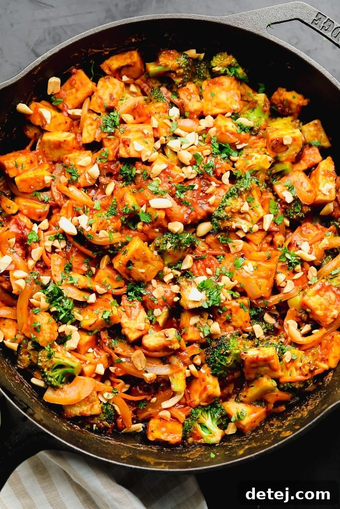 stir fry topped with broccoli and nuts in a cast iron skillet