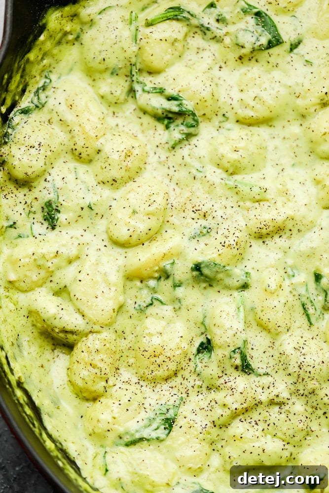 close up on creamy green gnocchi in a pot