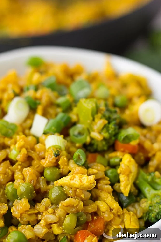 Golden Tofu Scramble Fried Rice 3 A very close-up shot of golden fried rice, highlighting the scrambled tofu and various chopped vegetables.