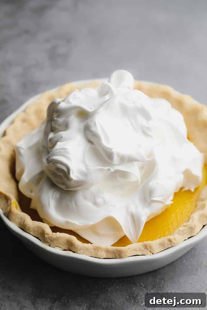 Aquafaba Essentials 2 A generous mound of perfectly whipped white vegan meringue crowning a delectable lemon pie, showcasing the versatility of aquafaba in creating classic desserts.