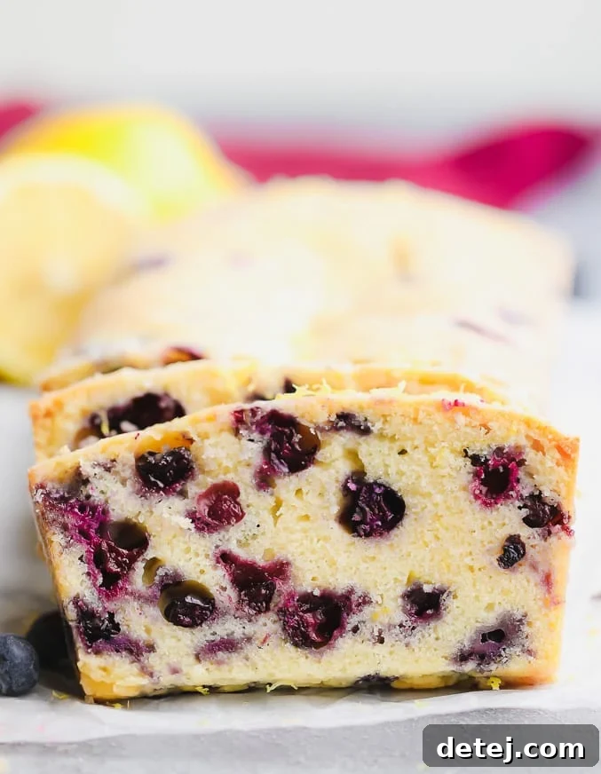 close up on a slice of blueberry bread, showing individual berries and fluffy texture