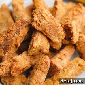 Close-up on a large plate filled with golden brown fried vegan chicken pieces
