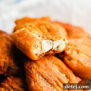 piece of vegan fried fish with a bite missing on top of a pile of more vegan fish