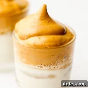 Close up on a glass with milk topped with whipped coffee