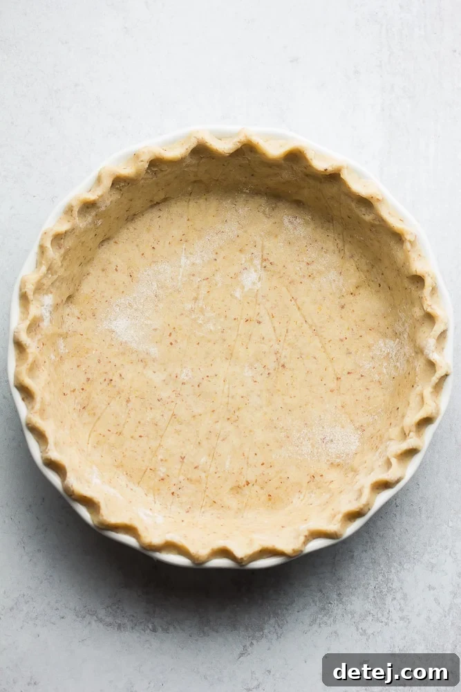An uncooked healthy pie crust, perfectly fluted and placed in a pie pan, ready for baking.