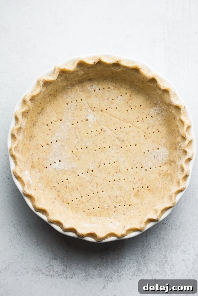 Uncooked pie crust with fork holes, ready to be baked for a delicious pie.