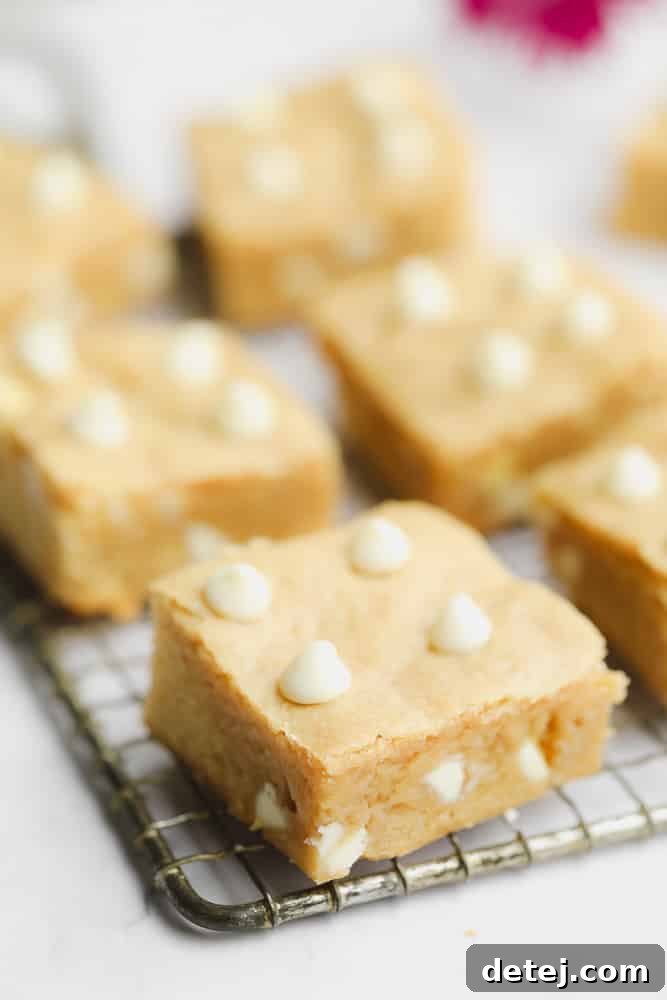 Baked blondies cut into squares sitting on a wire rack, cooling and ready to be enjoyed