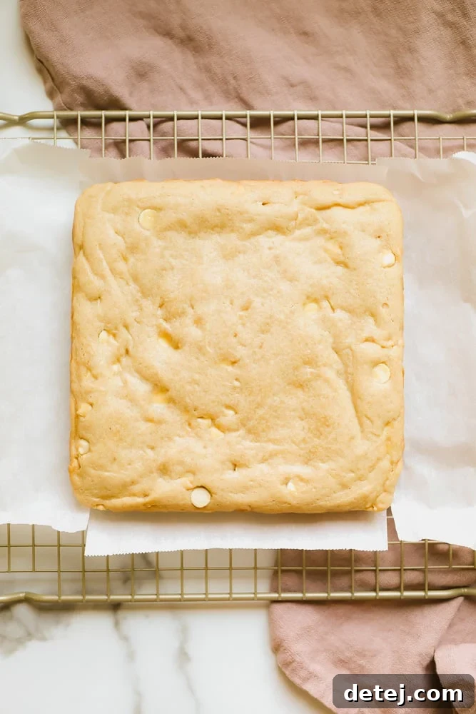 Light brown baked blondies cooling on a wire rack, steam gently rising