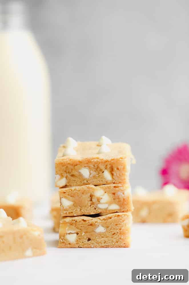 Three baked blondie squares piled on top of each other, showcasing their rich color and texture