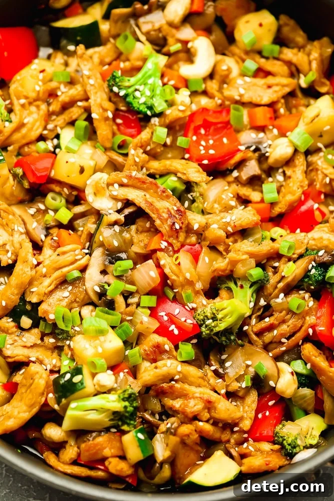 large platter with cooked stir fry veggies and soy curls, garnished with sesame seeds and green onions