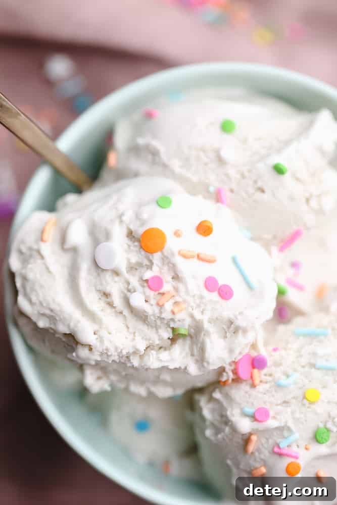 A close-up shot of several scoops of vanilla vegan ice cream topped with colorful sprinkles in a bowl, highlighting its inviting texture.