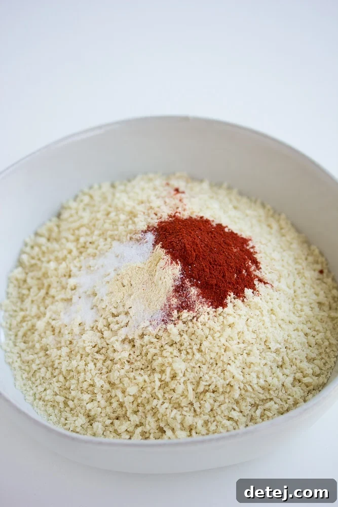 A bowl filled with panko breadcrumbs and various spices, mixed together for coating the tofu nuggets.