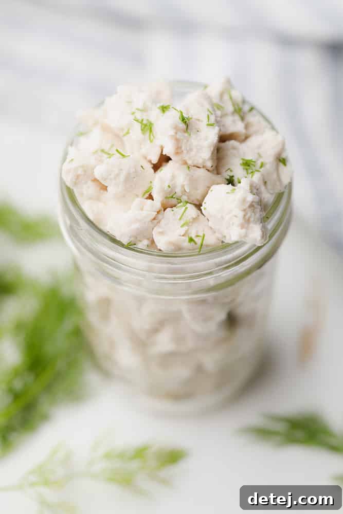 crumbled white pieces of vegan feta cheese in a glass jar, perfectly seasoned and ready to enjoy