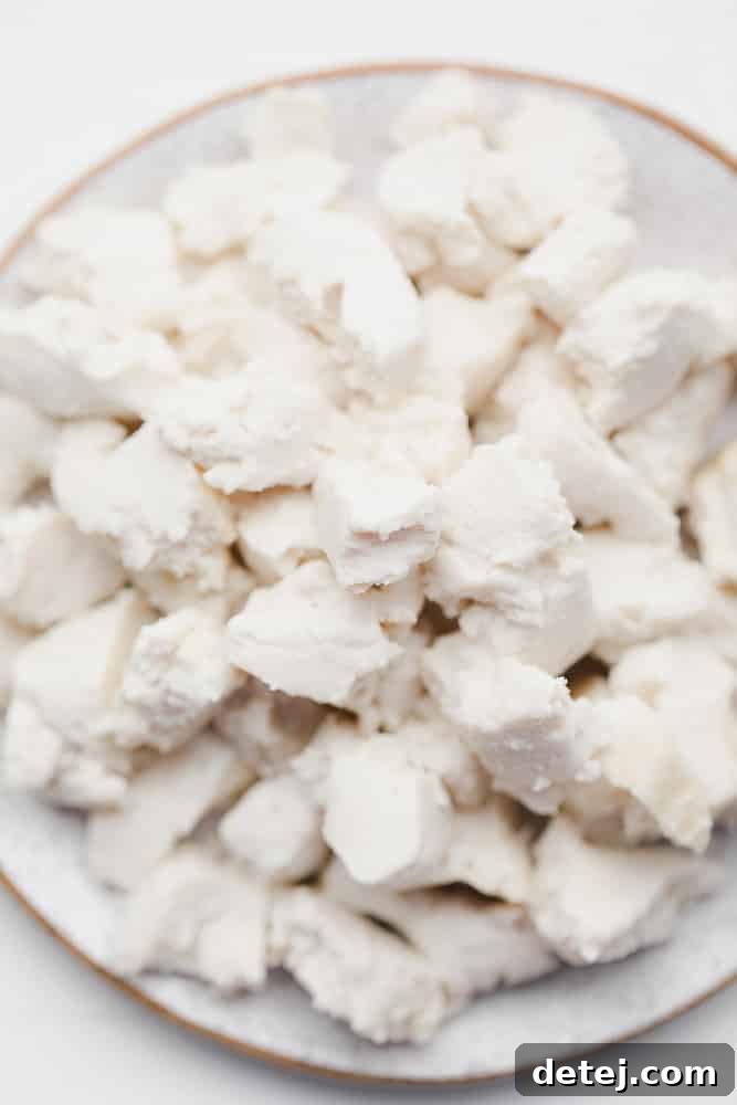 crumbled white cubes of vegan feta cheese on a white plate, ready to be served