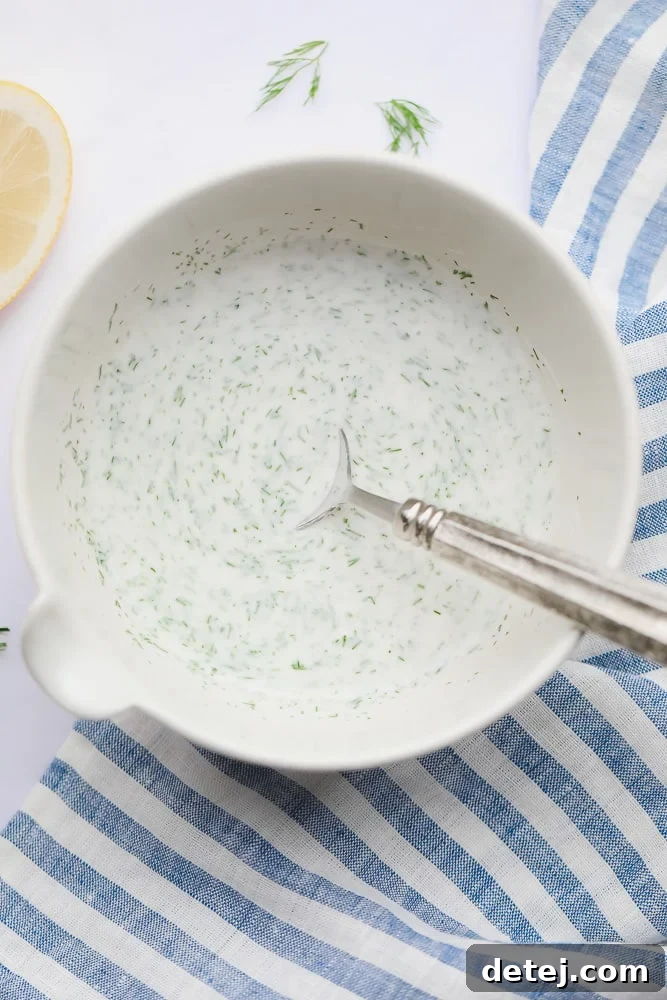 Creamy homemade shawarma sauce in a bowl, garnished with fresh dill.