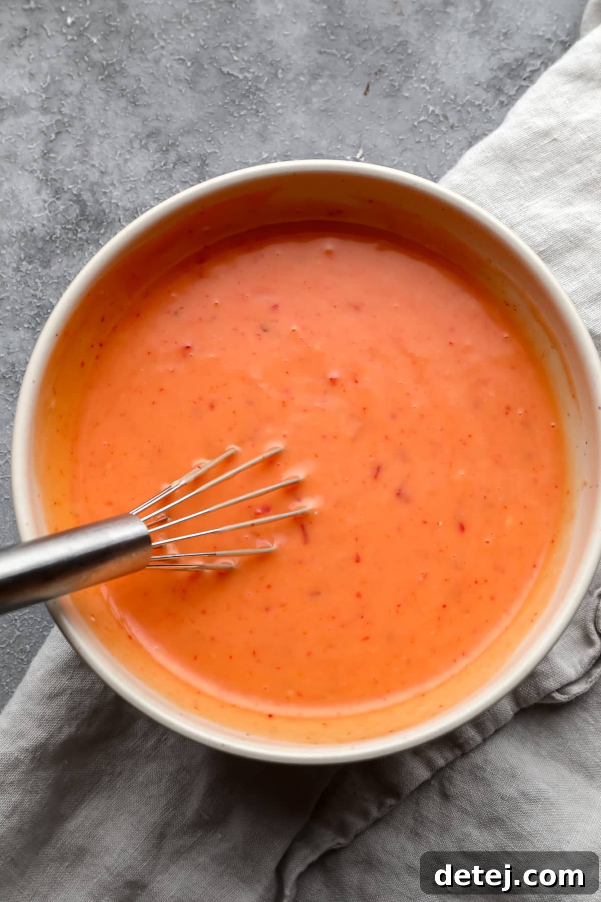 mixed bang bang sauce in a bowl with a whisk