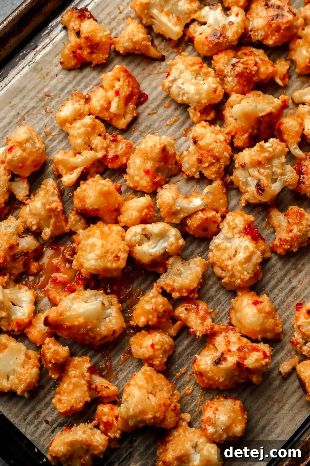 baked bang bang cauliflower on parchment lined baking sheet