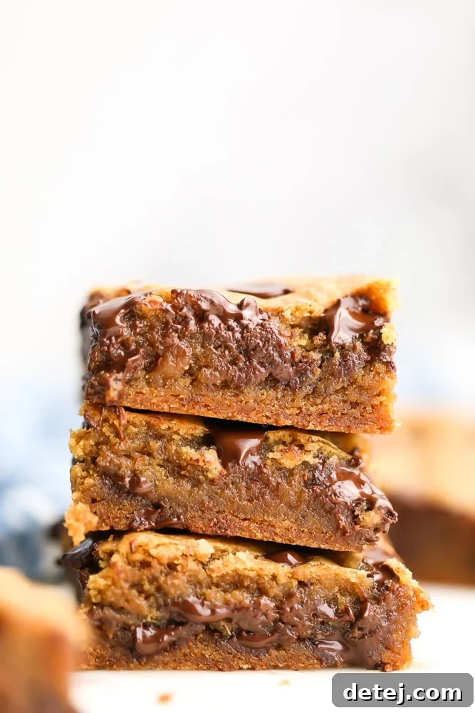 A delectable close-up photo of freshly baked vegan chocolate chip cookie bars, showcasing their golden-brown edges and gooey chocolate centers.