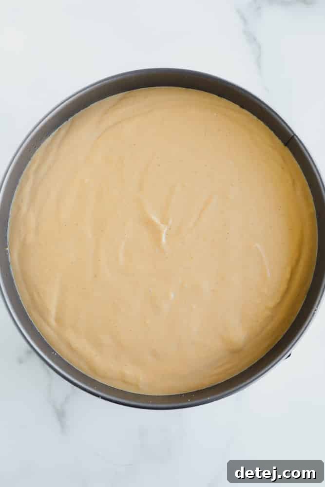 A light brown creamy mixture in a round metal pan.