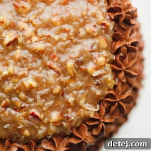 Close up on a frosted chocolate cake with a pecan caramel sauce on top.