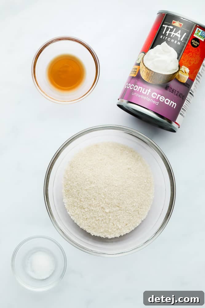 A can of coconut cream next to small glass bowls filled with sugar, vanilla extract, and salt—the simple ingredients for vegan condensed milk.