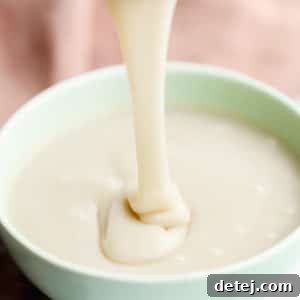 square image of pouring white sauce into green bowl