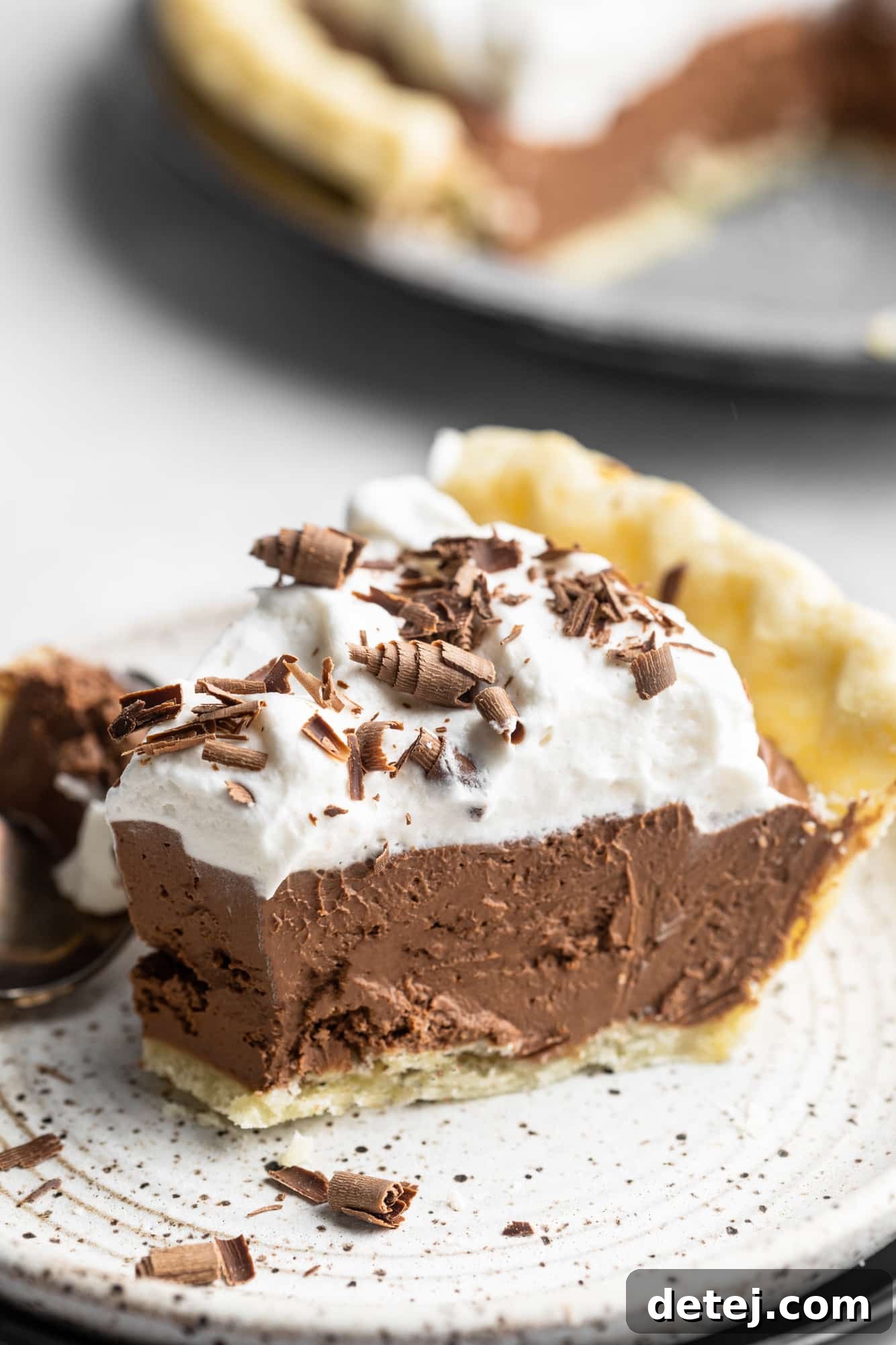 Velvet Vegan Chocolate Indulgence 9 a slice of vegan chocolate pie with a bite removed on a small white plate.