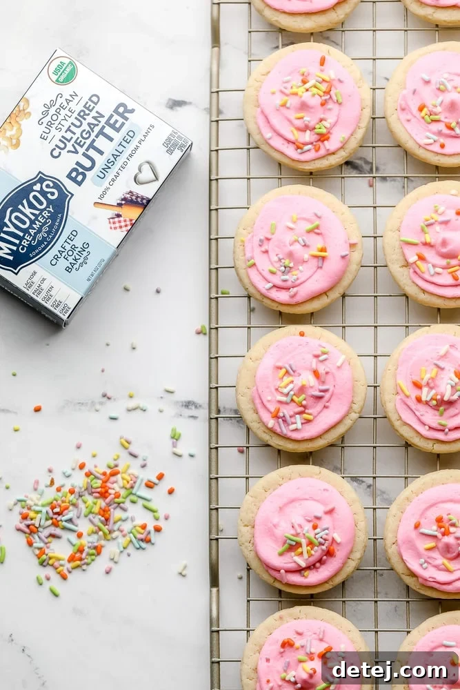 Miyoko's butter packaging next to a cooling rack laden with frosted vegan Lofthouse cookies.