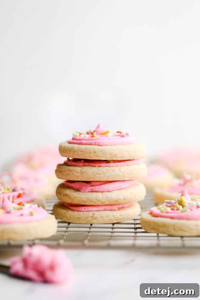 A towering stack of soft, frosted vegan Lofthouse sugar cookies, presented against a clean white background.