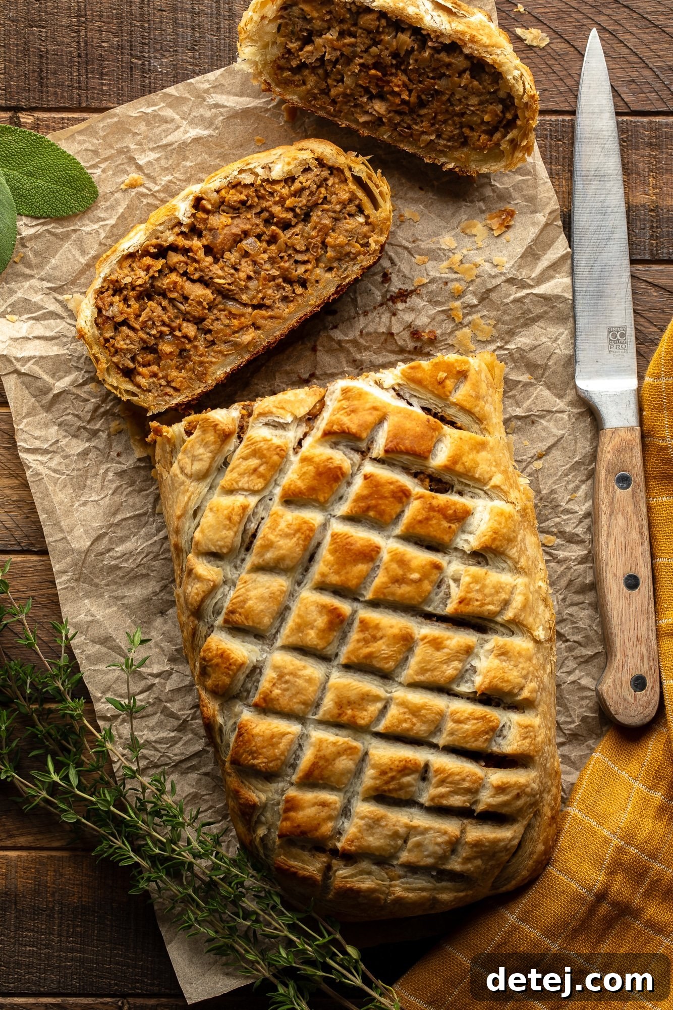 Overhead view of a perfectly sliced vegan wellington on a sheet of parchment paper, ready to be served.