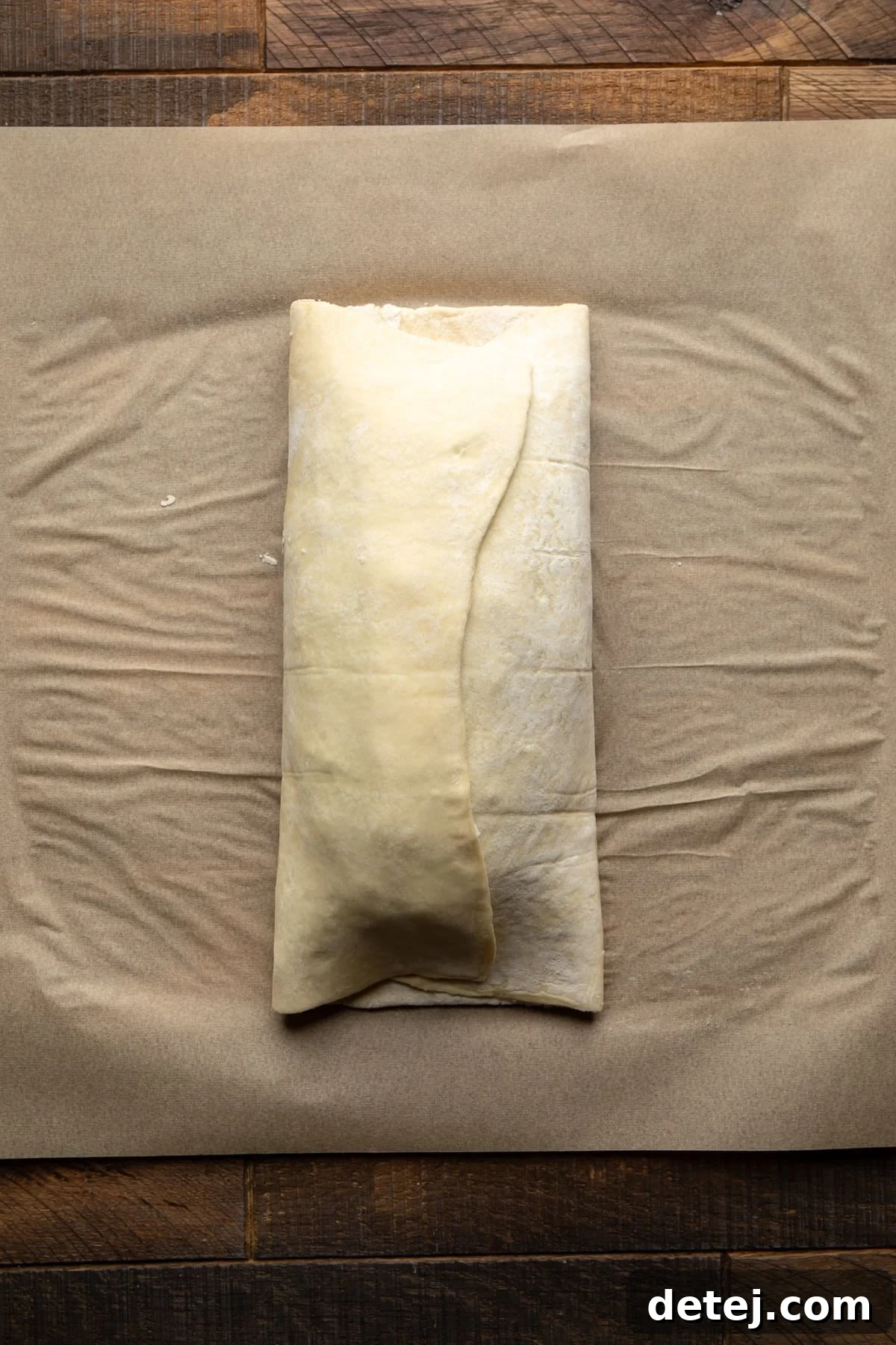 Another view of the partially assembled pastry-wrapped vegan wellington, demonstrating the folding technique.