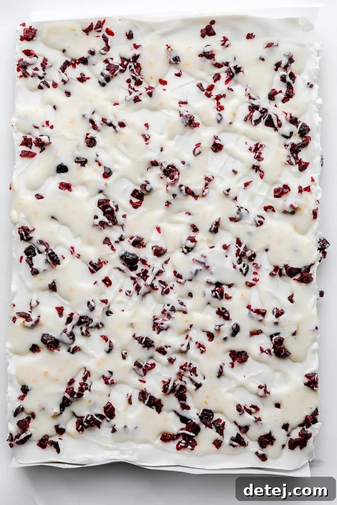 overhead view of vegan white chocolate cookie bars topped with dried cranberries.