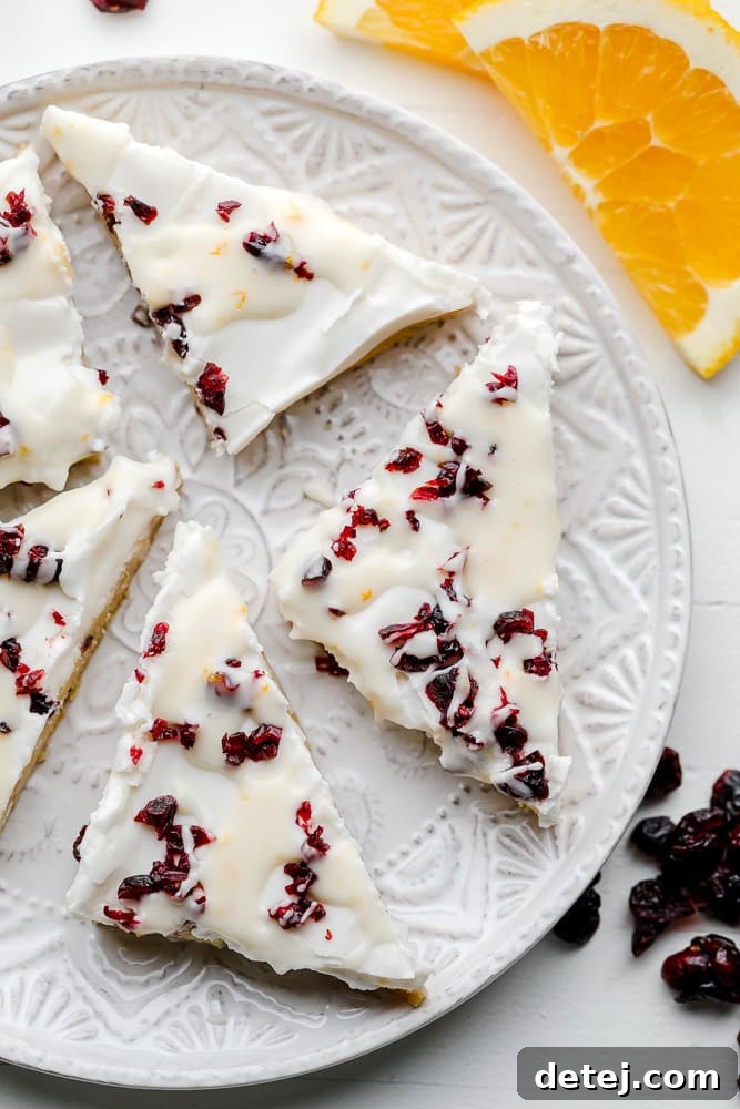white chocolate and cranberry cookie bars on a decorative white plate.