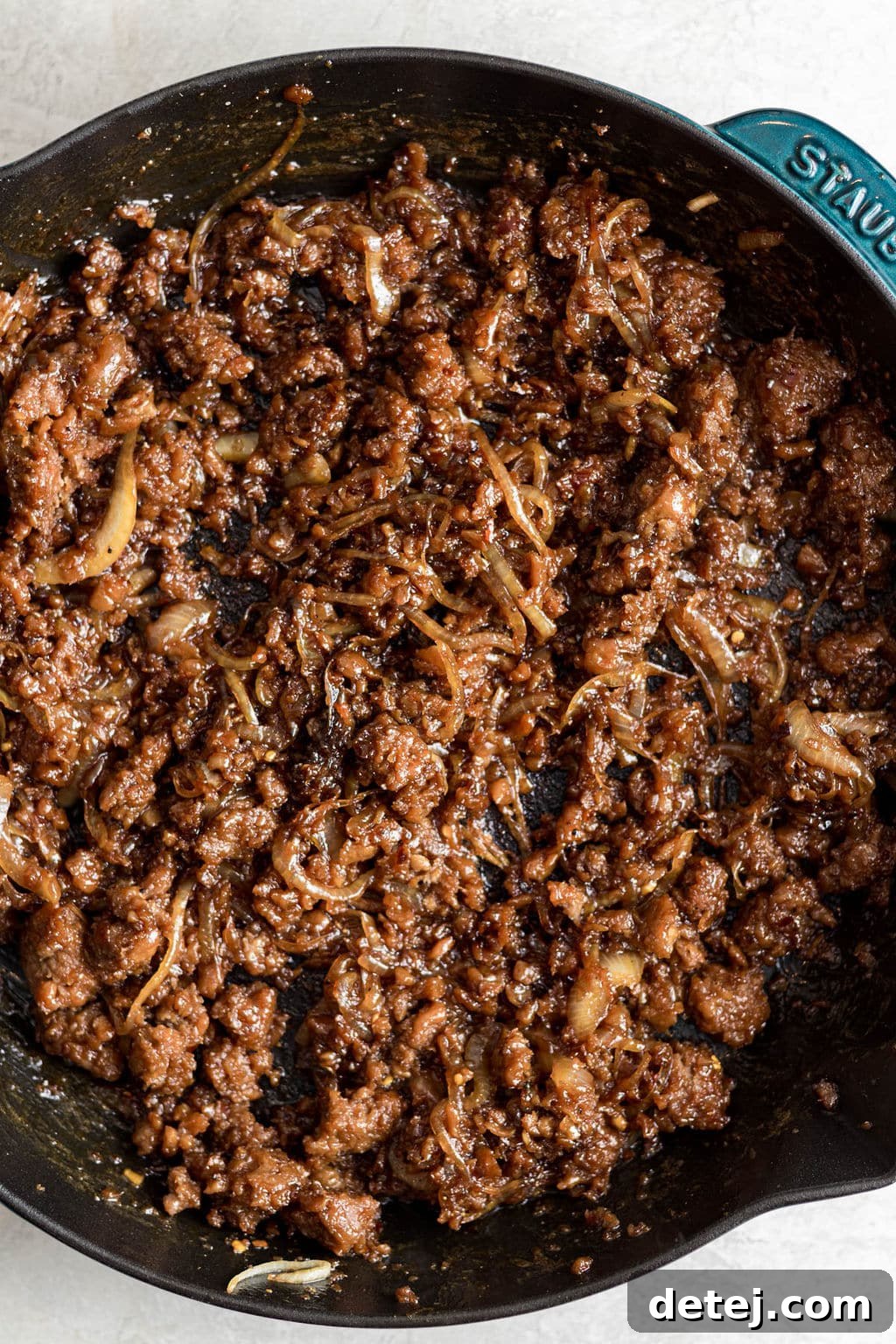 cooked vegan ground beef and onions in a black skillet.