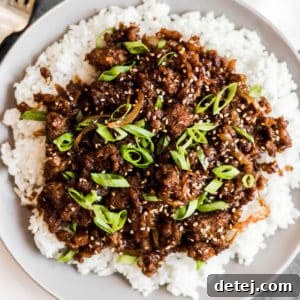 close up on white rice and cooked ground vegan beef on a white plate.