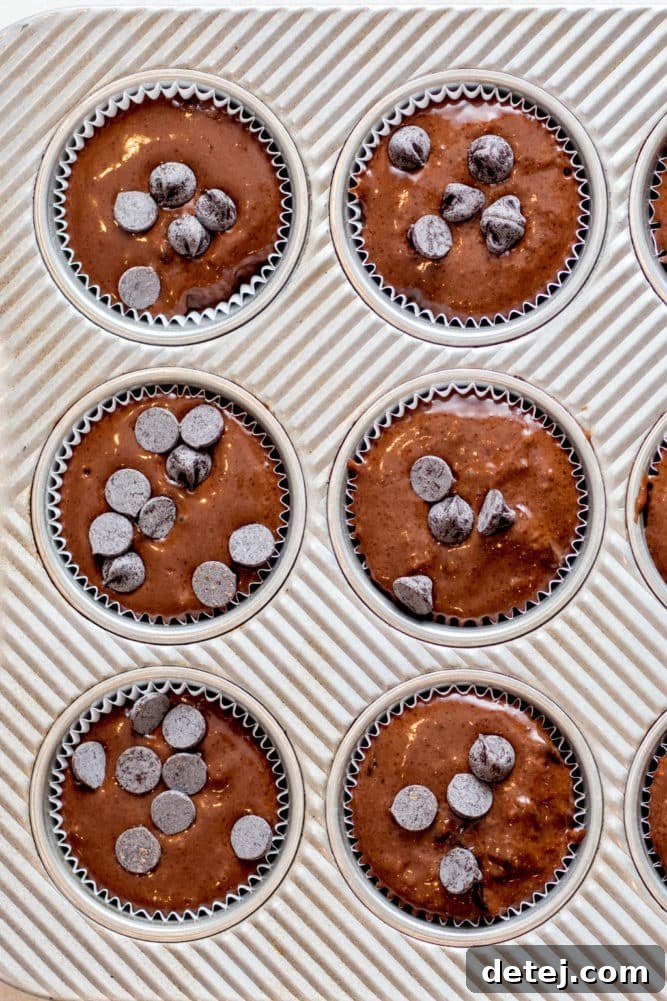 overhead view of chocolate muffin batter in a metal baking tin.