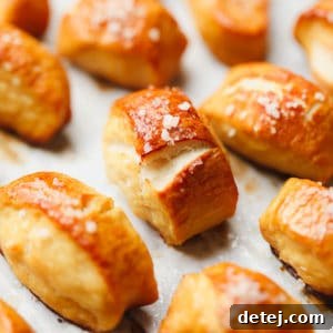 Square image of vegan pretzel bites arranged on parchment paper, ready to be served.