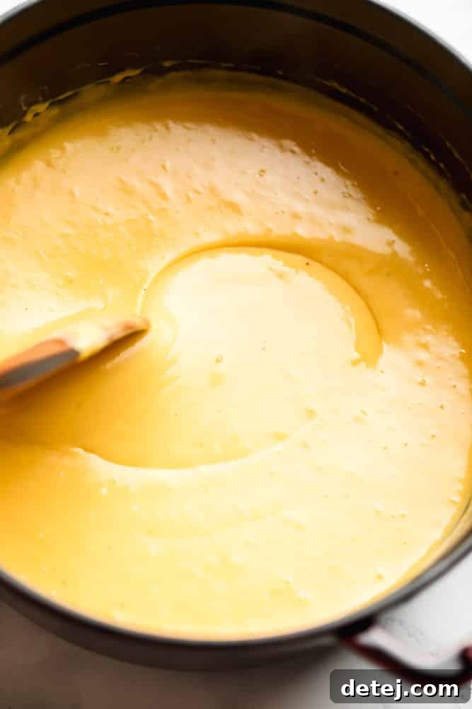 a spoon stirring cheese sauce in a pot