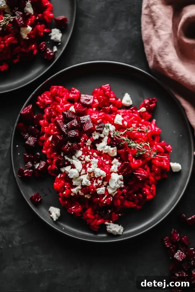 Crimson Velvet Risotto 2 Two plates of vibrant red beetroot risotto topped with vegan cheese and roasted beets, ready to be served.