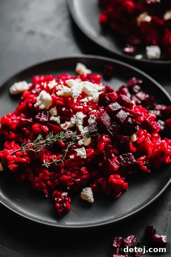 Crimson Velvet Risotto 4 Close-up shot of a single plate of beetroot risotto, garnished with extra roasted beets and crumbled vegan cheese.