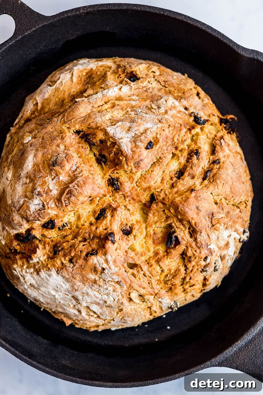 Another view of the delicious baked vegan Irish soda bread in a black cast iron pan, ready to be enjoyed.