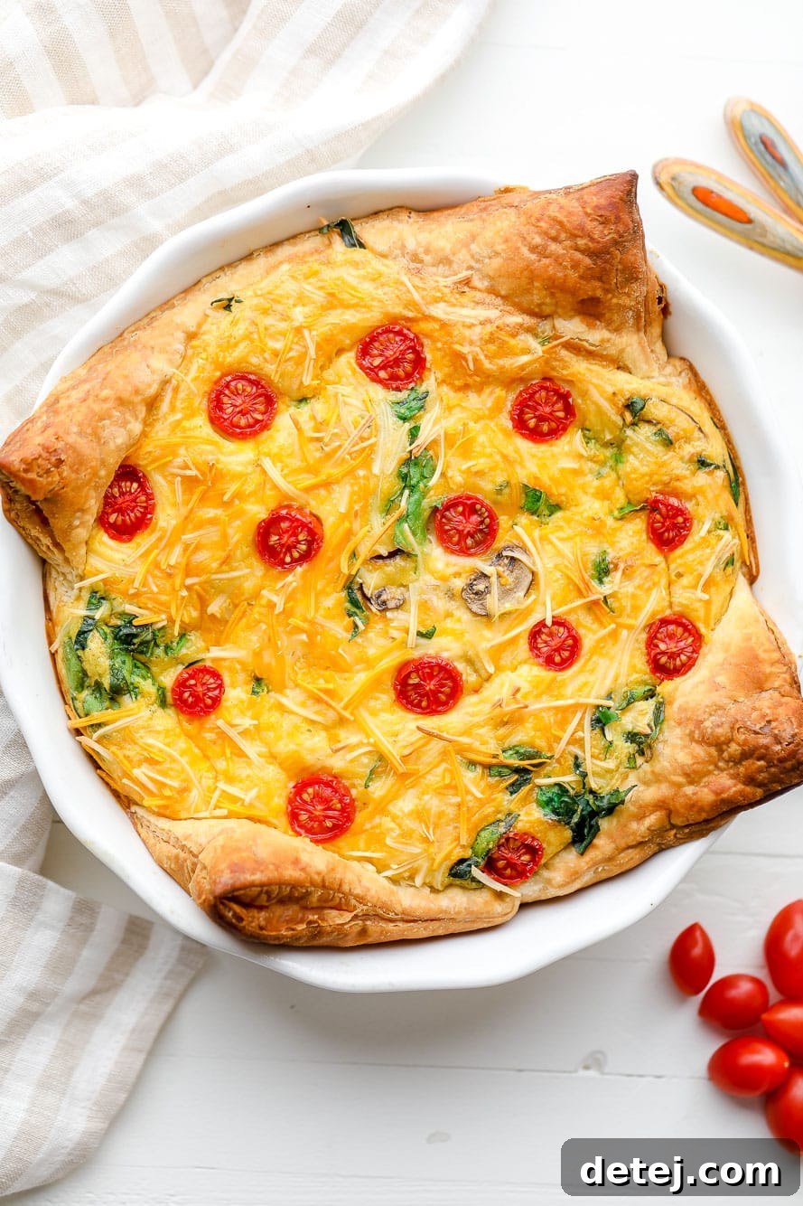 A perfectly baked, golden-brown JUST Egg quiche resting in a white pie plate, ready to be served. Ideal for a vegan brunch centerpiece.