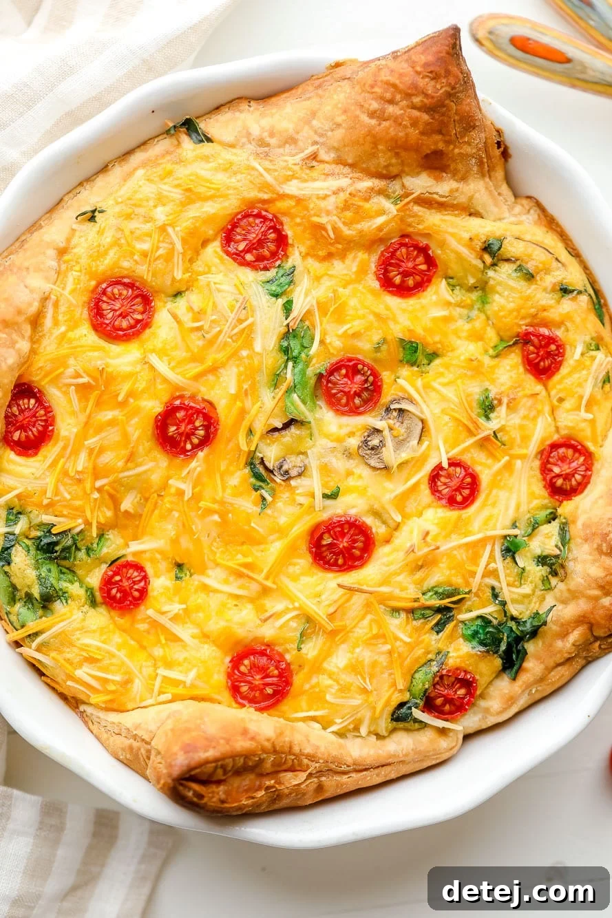 A close-up view of a baked JUST Egg quiche in a white pie plate, revealing its golden crust and vibrant, custardy filling. Perfect for a vegan breakfast or brunch.