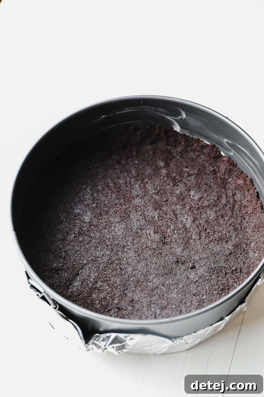 An Oreo cookie crust, perfectly pressed into the bottom of a springform pan, ready for the filling.