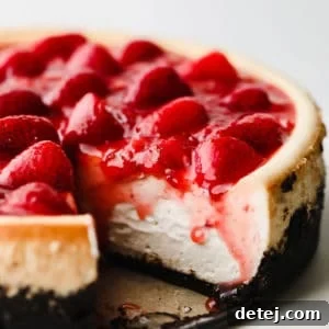 close up of a vegan strawberry cheesecake with a slice cut out.