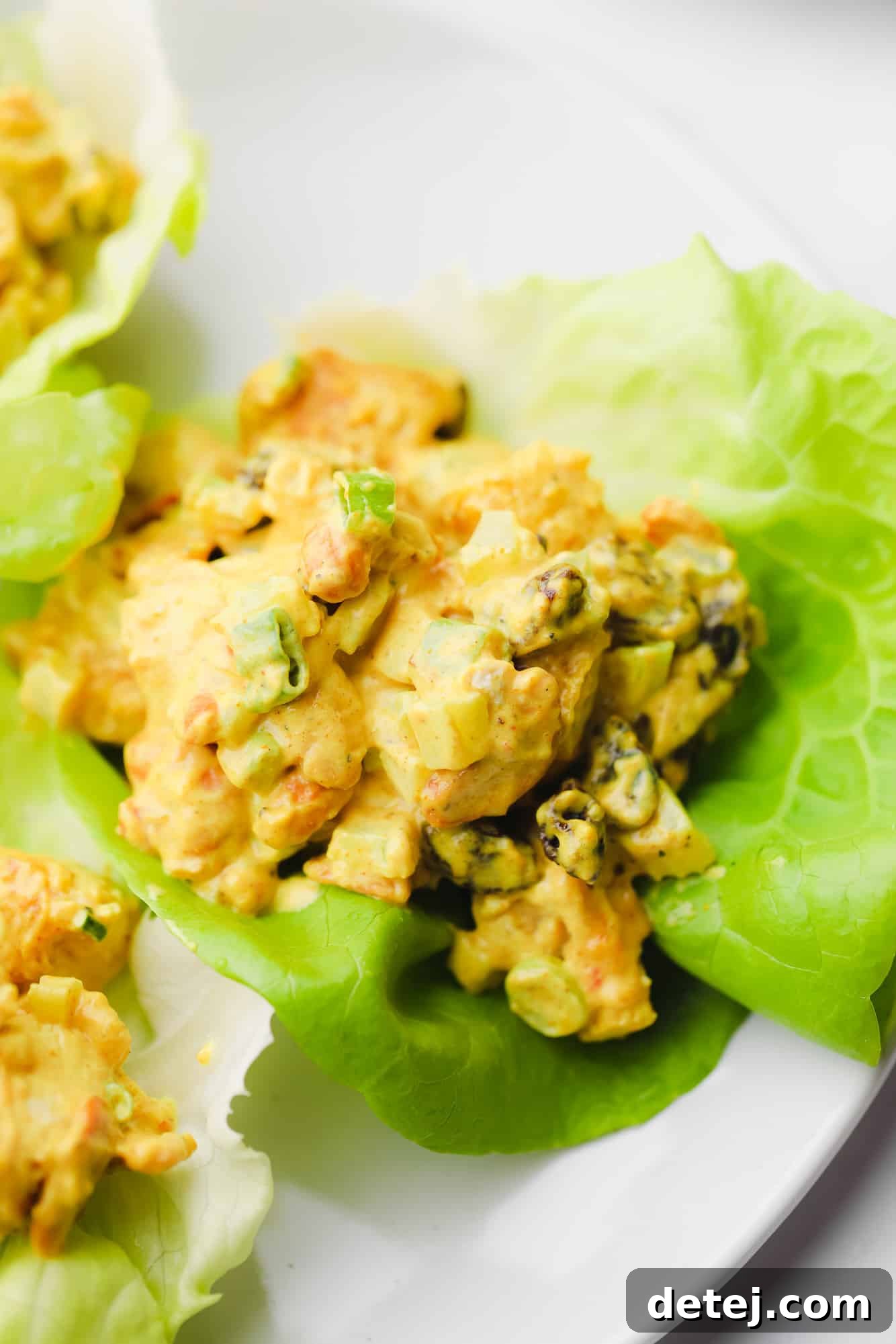 Golden Curried Tofu Salad 2 close up on a creamy curry tofu salad in a lettuce cup.