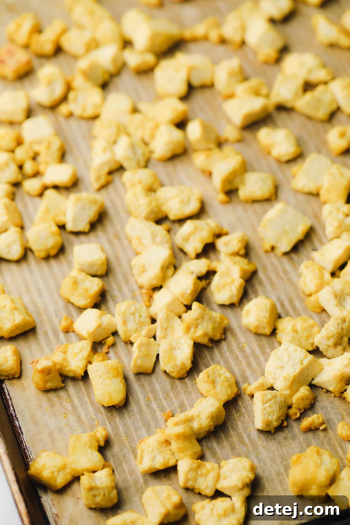 Golden Curried Tofu Salad 4 baked tofu cubes on a metal sheet pan.