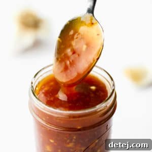 Effortless 5 Minute Stir Fry Sauce 6 A sauce-covered spoon coming out of a jar of stir fry sauce.