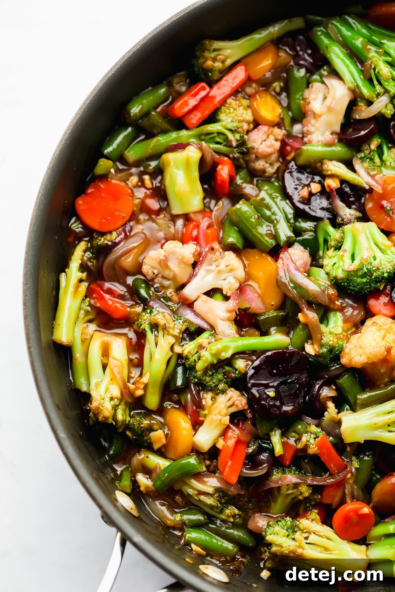 Sauce-covered cooked vegetables in a large black skillet, ready to be served.