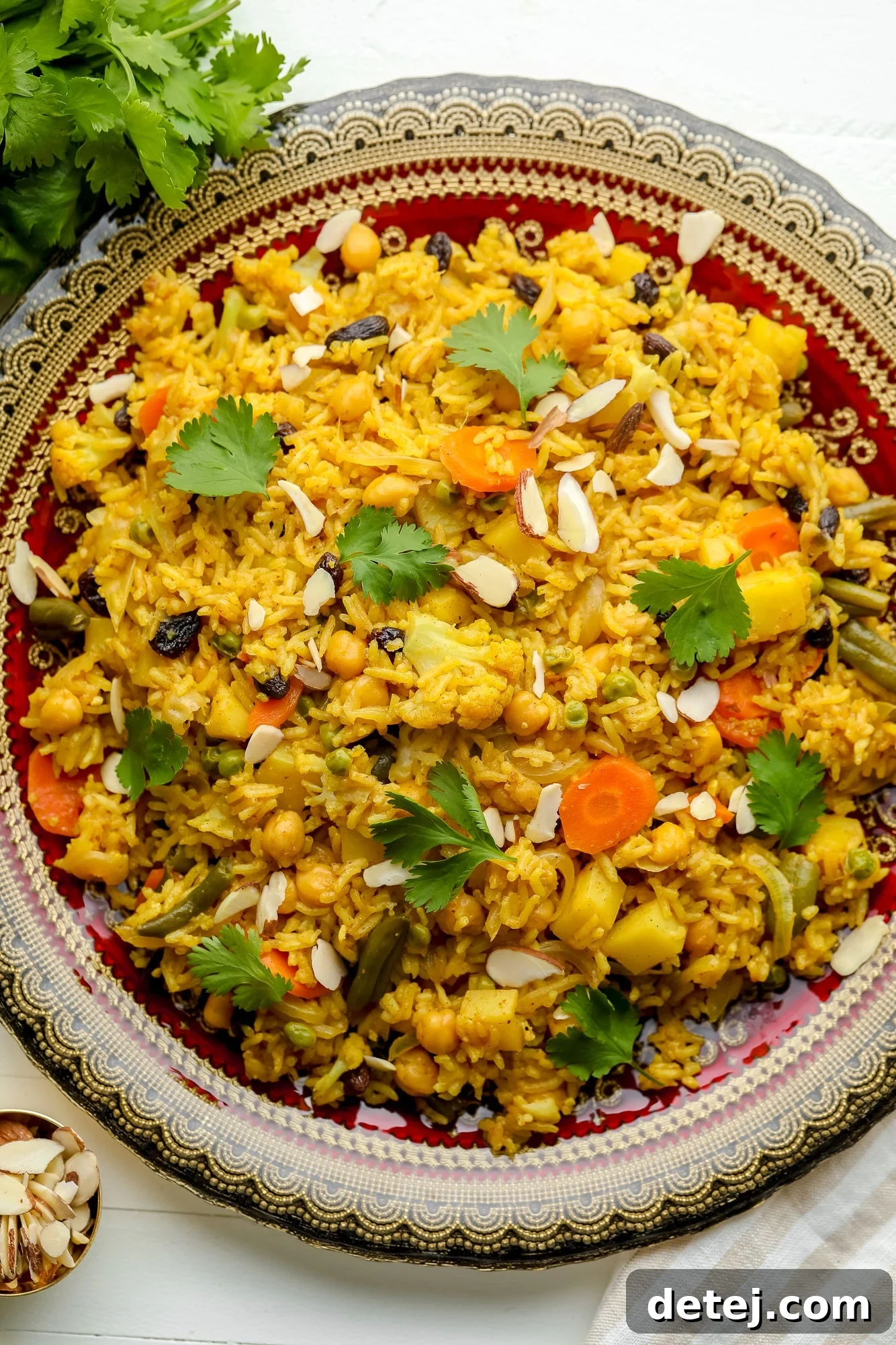 A large, decorative plate showcasing a vibrant serving of Easy Vegan Biryani, highlighting the colorful vegetables and aromatic rice.